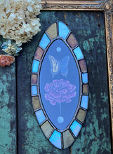 Load image into Gallery viewer, Full view of oval shaped piece, bronze and opal checkered border, with painted pearl, swallowtail, carnation, and final pearl in line in center on black background.