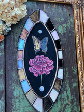 Load image into Gallery viewer, Full view of oval shaped piece, bronze and opal checkered border, with painted pearl, swallowtail, carnation, and final pearl in line in center on black background.