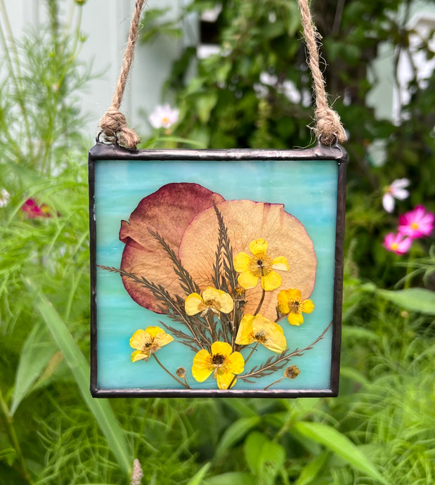 Spring buttercups, rose petals, lace leaf maple with dark wispy green/blue glass backing