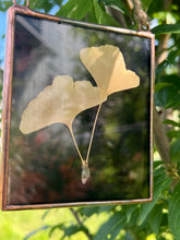 Load image into Gallery viewer, Another view showing reflection on front of glass - Single golden yellow gingko leaf with dark wispy purple/dark maroon glass backing
