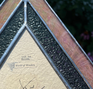 Found word poetry on backside. “Wait for flowers. World of wonders.” Gouache landscape set between glass with pressed wildflowers. Iridescent pink and textured clear glass border.