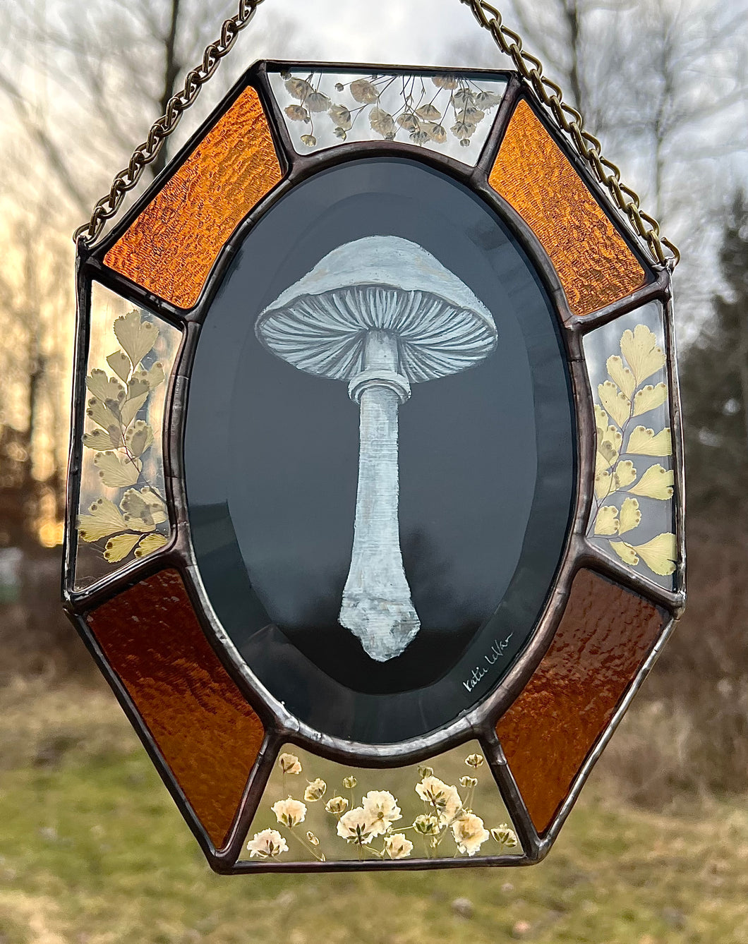 Painted white porcelain fungus on black background  in center with alternating amber glass and clear glass with floral inclusion border. Gouache on paper with pressed gypsophila and maidenhair fern set between glass, with amber glass.