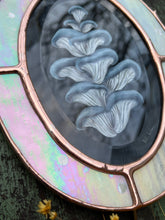 Load image into Gallery viewer, Bottom third view of artwork. Blue oyster mushroom gouache painting on black. Oval shaped glass hanging wall art with oval rainbow iridized glass border and chain
