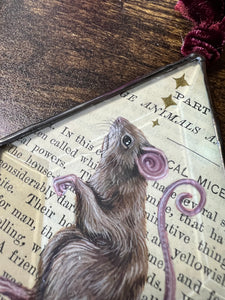 Close up of painted mouse - Painted brown mouse and golden stars. Diamond shape. Gouache and gilding paint on vintage book page in beveled glass.