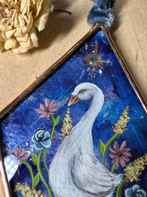 Load image into Gallery viewer, Close up of painted goose - White goose painting on blue dyed paper with pink, blue, and yellow flowers surrounding it at the base. Gold painted sun above goose. Diamond shape. Gouache painting on hand dyed paper in beveled glass.
